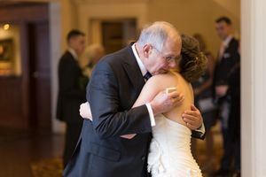 Wedding reception guests gather in a warmly lit indoor venue with elegant decor.
