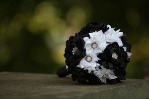 Black and white floral bouquets and decorative elements arranged on a rustic surface.
