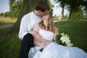 Romantic wedding couple shares intimate moments in a lush outdoor garden setting during their special day.