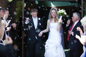 Wedding guests blowing bubbles during an outdoor celebration.