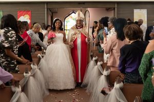 A group of wedding guests dancing and celebrating at a reception.