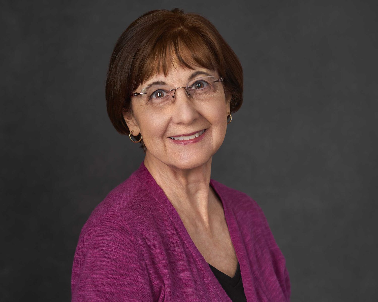 Older woman headshot in magenta sweater