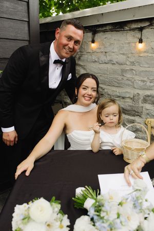 bride and groom and flower girl signing