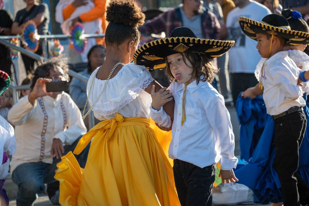 Dancers in traditional Mexican costumes and sombreros performing at a cultural celebration.