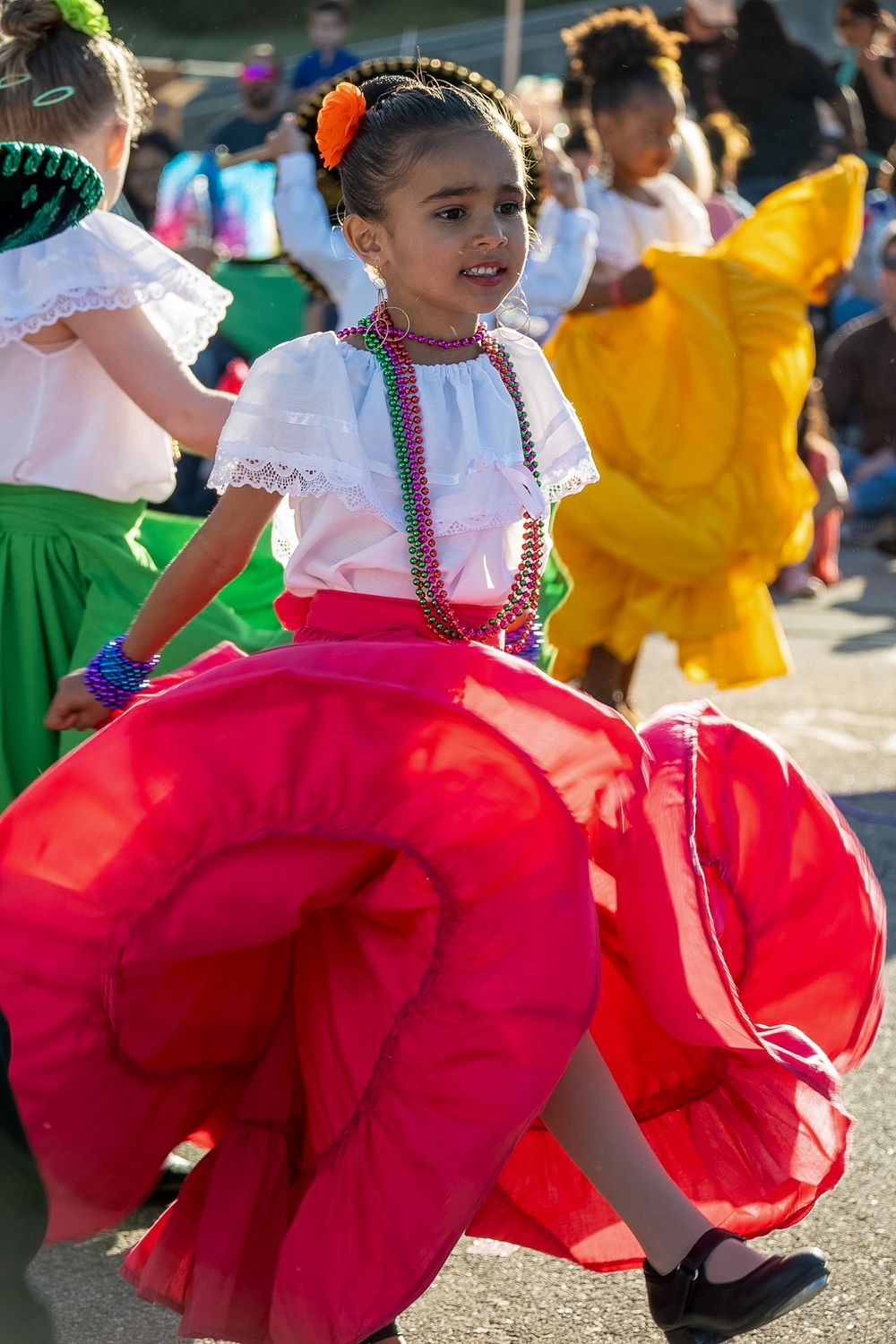 Dancer twirls in vibrant red traditional dress during cultural performance.