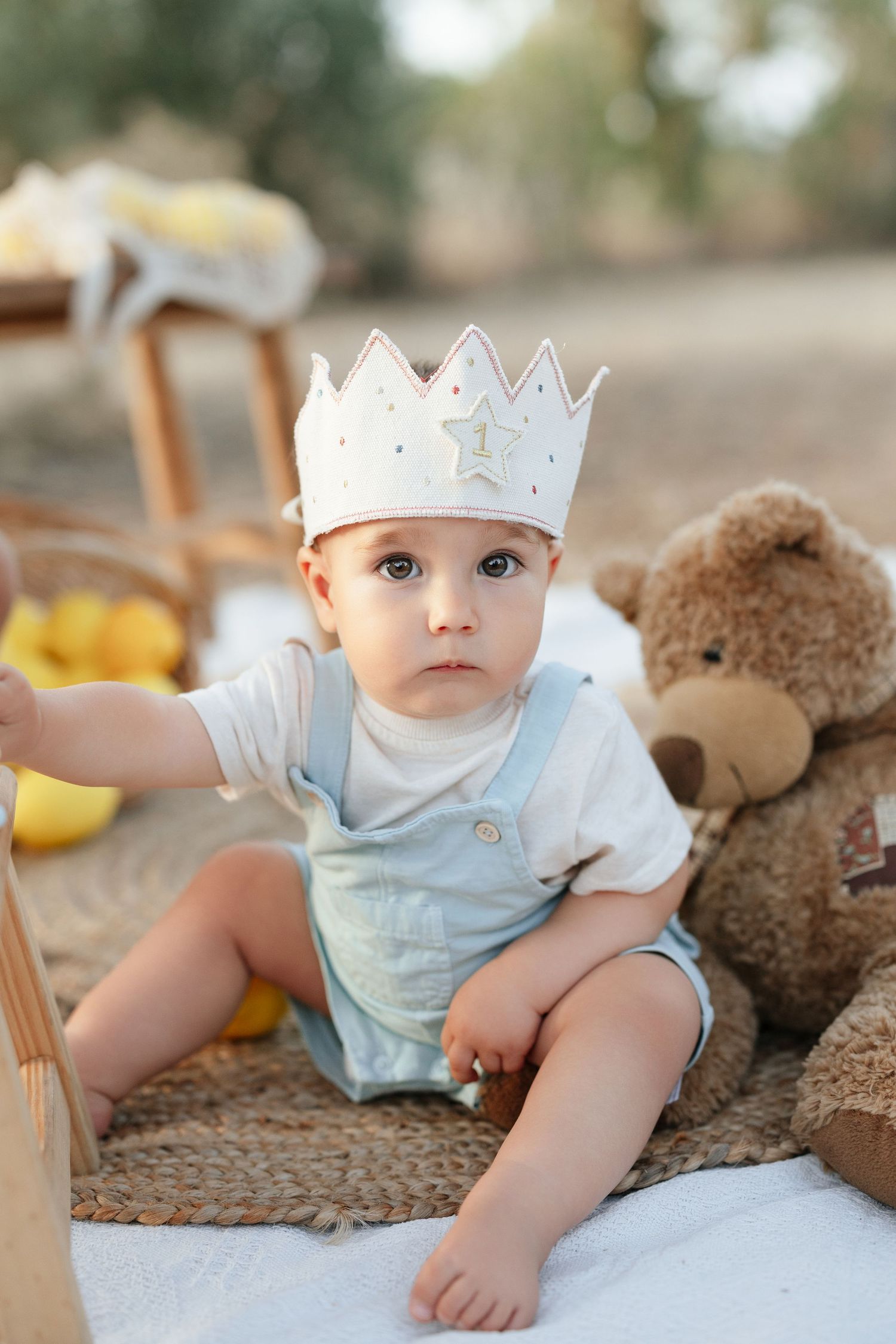 A first birthday cake smash photo session in a snowy field with mint green and gold balloon decorations.