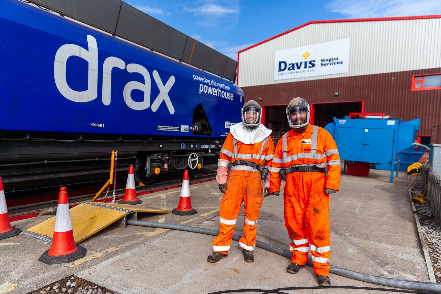 photograph of 2 operative dressed in PPE for blast cleaning a freight waggon