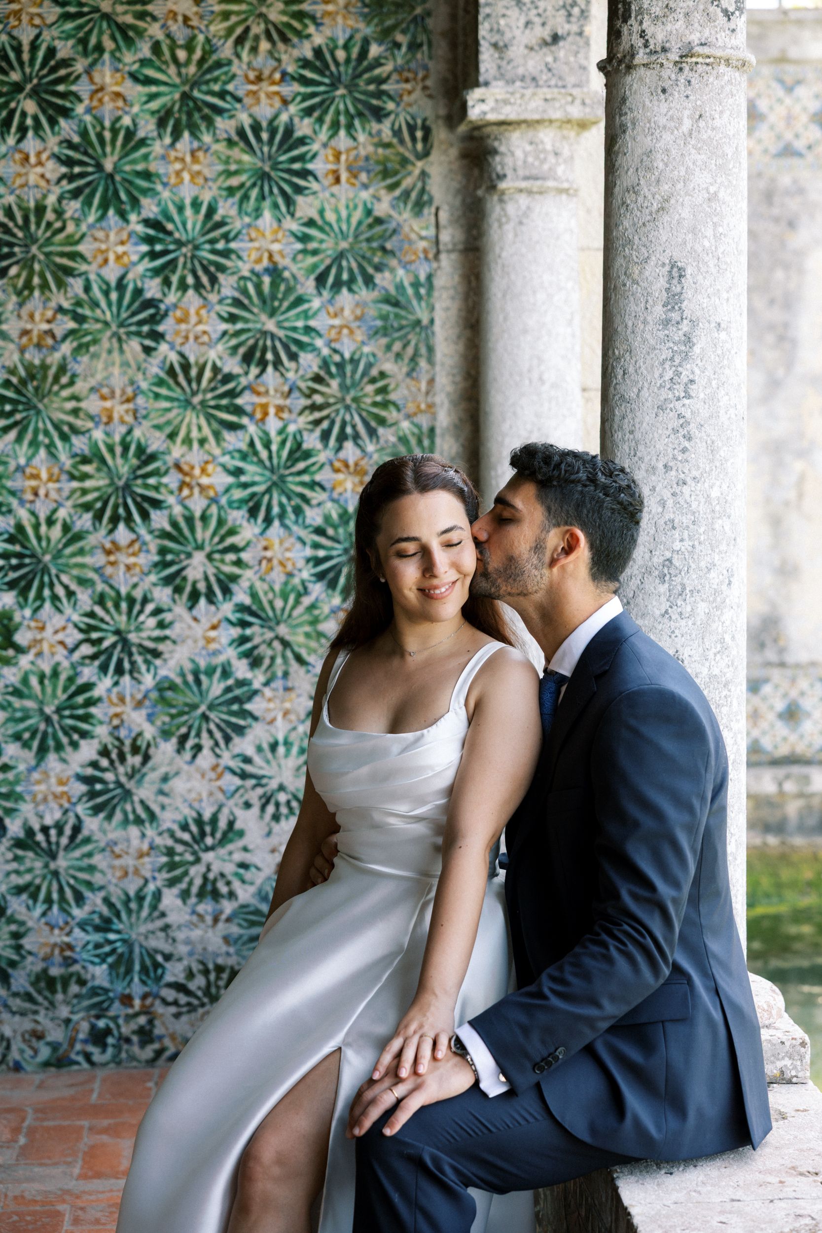 Bride and groom in front of historic azulejos at Palácio da Bacalhôa Portugal