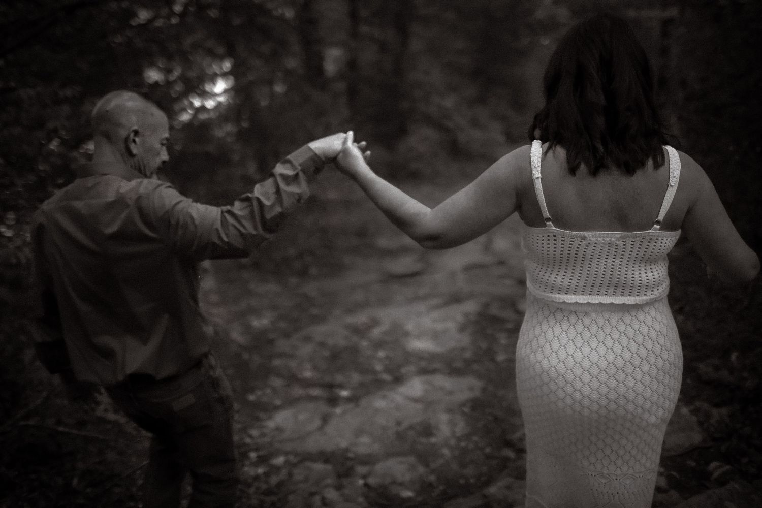 Couple walking together through the woods at sunset—romantic fall anniversary portraits by Amber Potter Photography