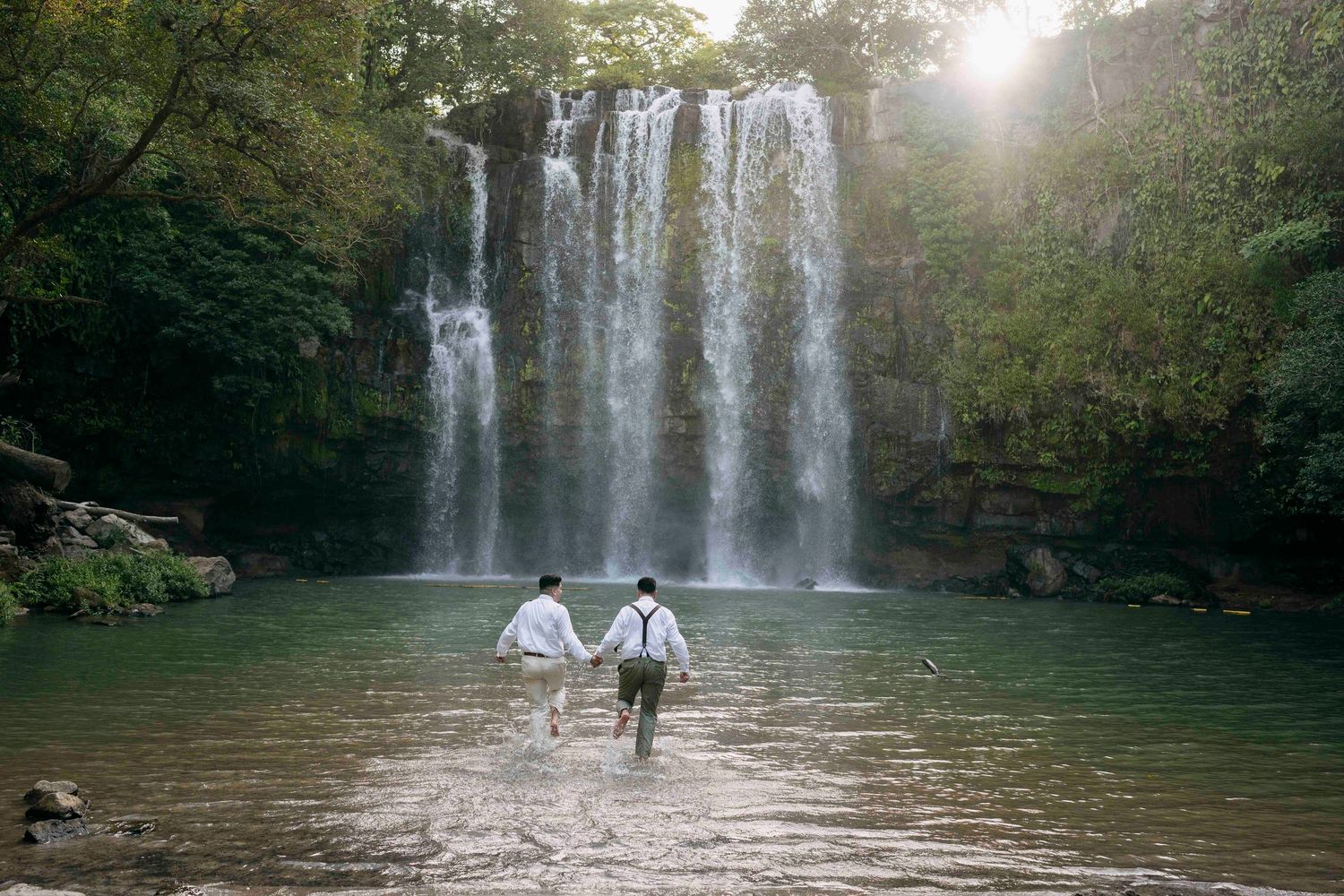 After saying their vows couple jumps into the amazing Llanos de Cortes waterfall in Costa Rica Guanacaste