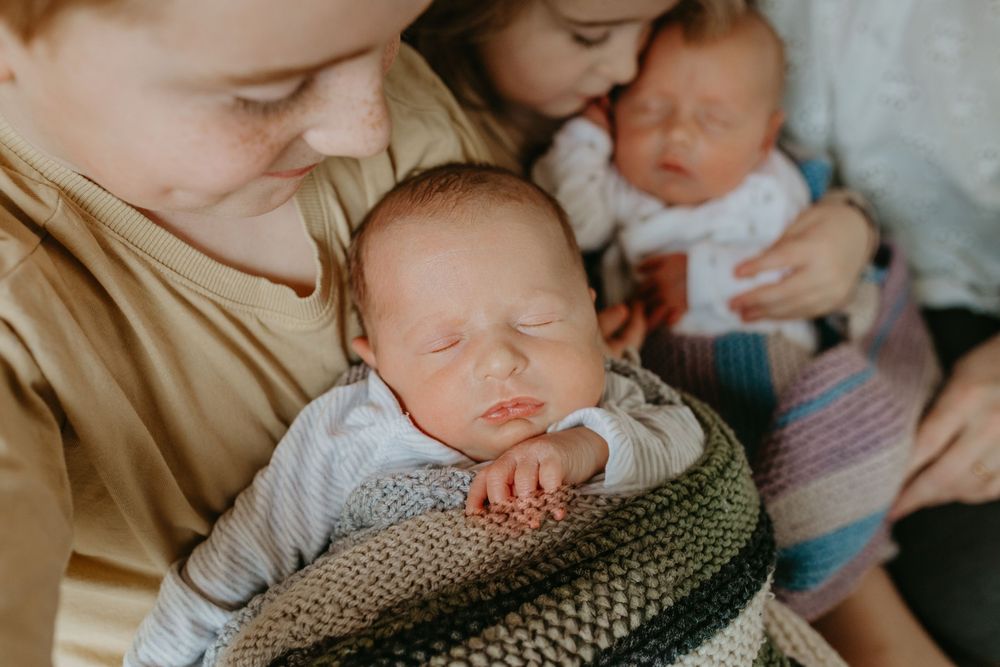 A collage of sleeping newborn babies wrapped in cozy blankets and knitted wraps in soft neutral tones.