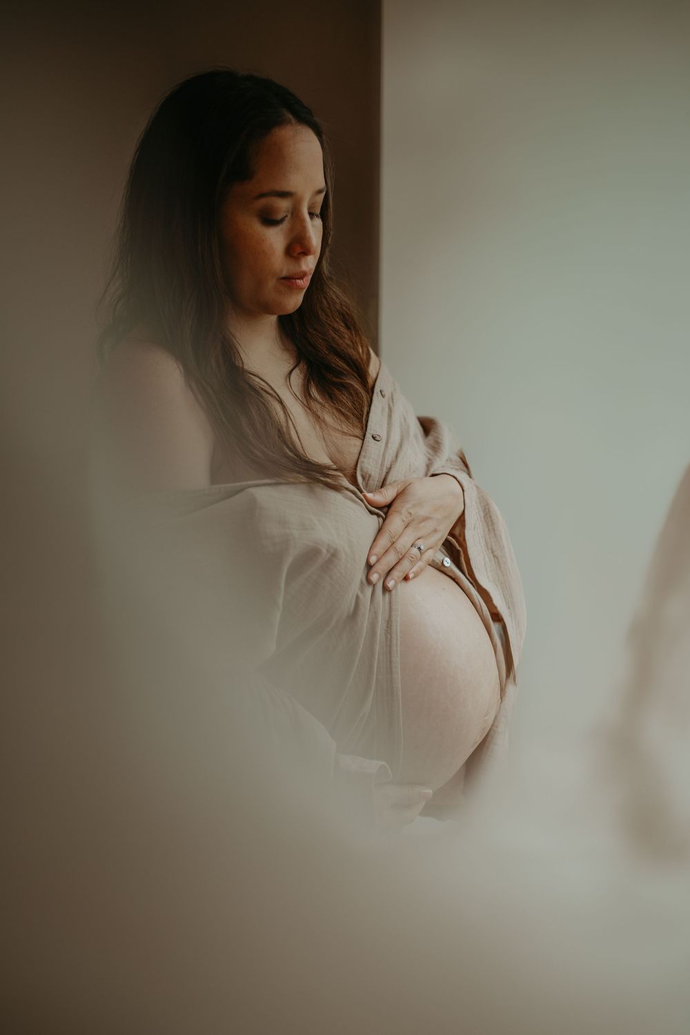 Artistic portrait series with soft focus and dreamy lighting shows a figure in white against a light neutral background.