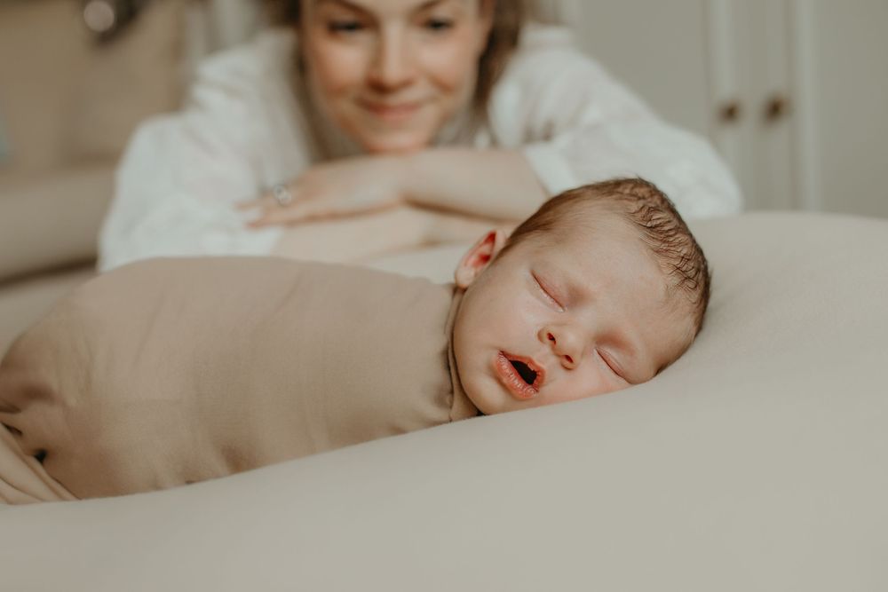 A tender family moment captured in a series of warm-toned photographs showing parents bonding with their newborn baby.
