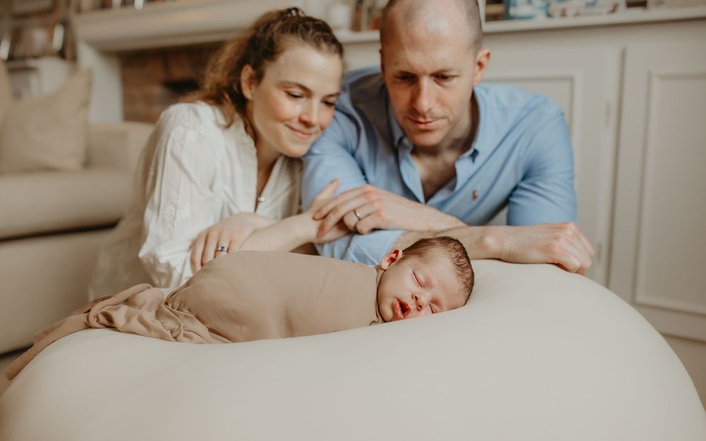 A collection of intimate family portraits showing loving interactions between parents and their newborn in a soft, neutral setting.