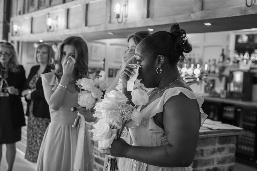 Wedding guests laugh and celebrate during a joyous reception at a rustic venue.