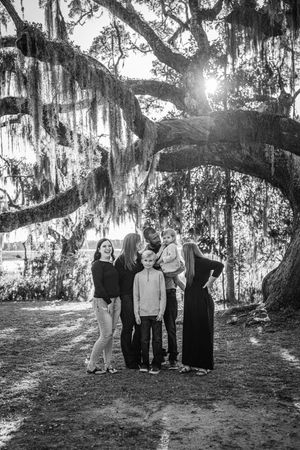 Group portrait under a majestic oak tree with hanging Spanish moss at sunset.