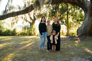 Family portrait session under a majestic oak tree with Spanish moss at sunset.
