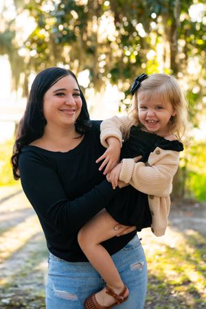 Joyful outdoor photoshoot with laughter and hugs in golden sunlight.
