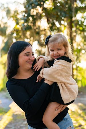 Candid moments of affection captured in a sun-dappled outdoor setting.