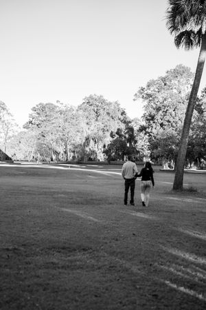 Black and white photo of people walking through a scenic park landscape.