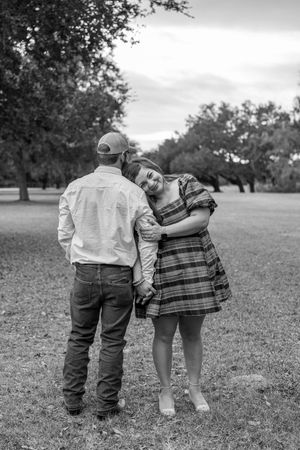 Two young children standing together in a grassy field shown in a series of black and white photos.