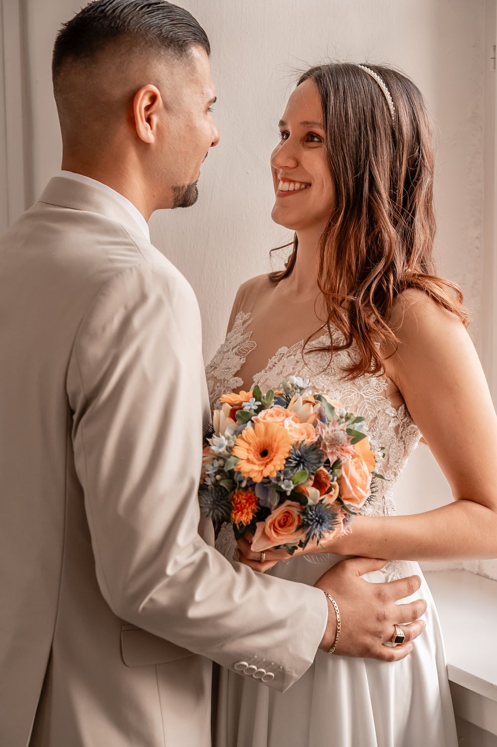 A romantic wedding photoshoot series showing tender moments between a couple with a peach and blue floral bouquet.