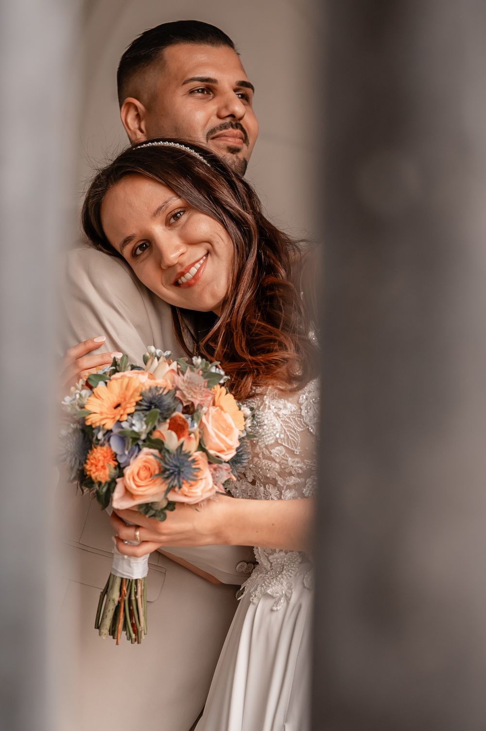 Romantic wedding photoshoot with peach and blue floral bouquet in soft lighting.