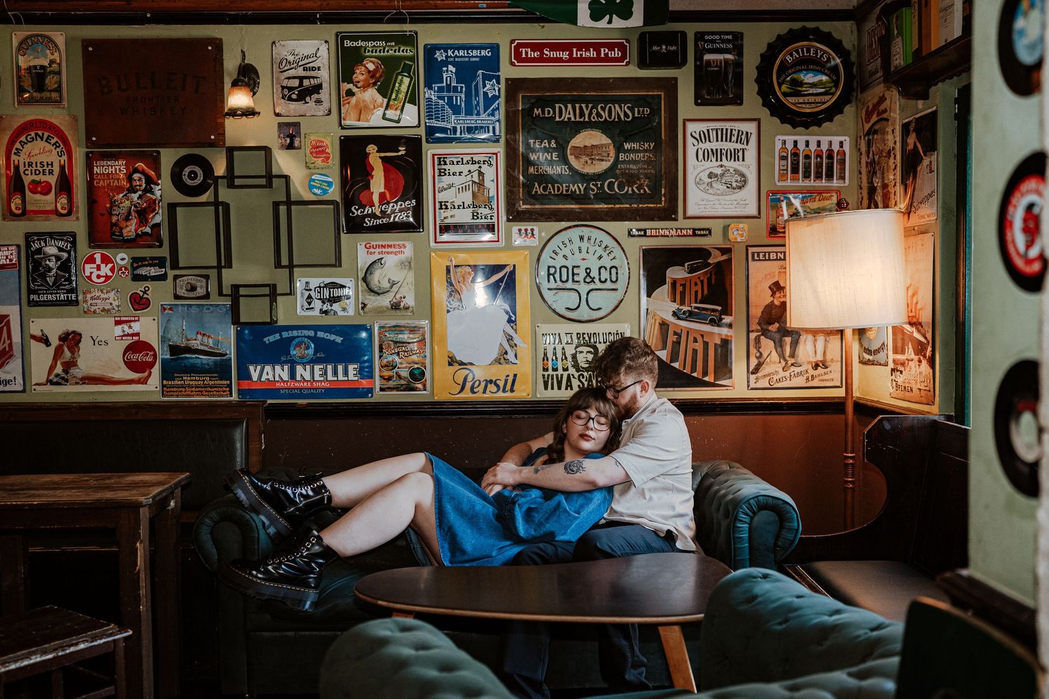 Intimate romantic couple sharing tender kisses in moody lighting with warm orange glow.