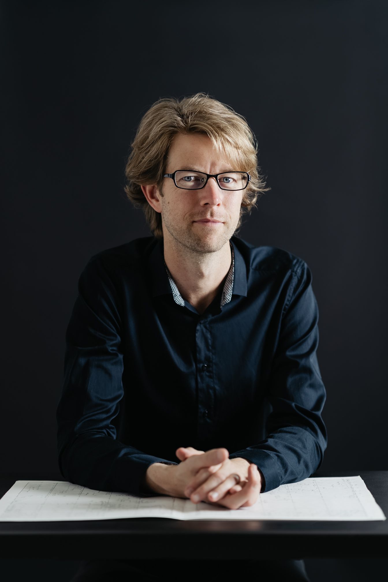 Portrait series against dark background showing contemplative poses with book.