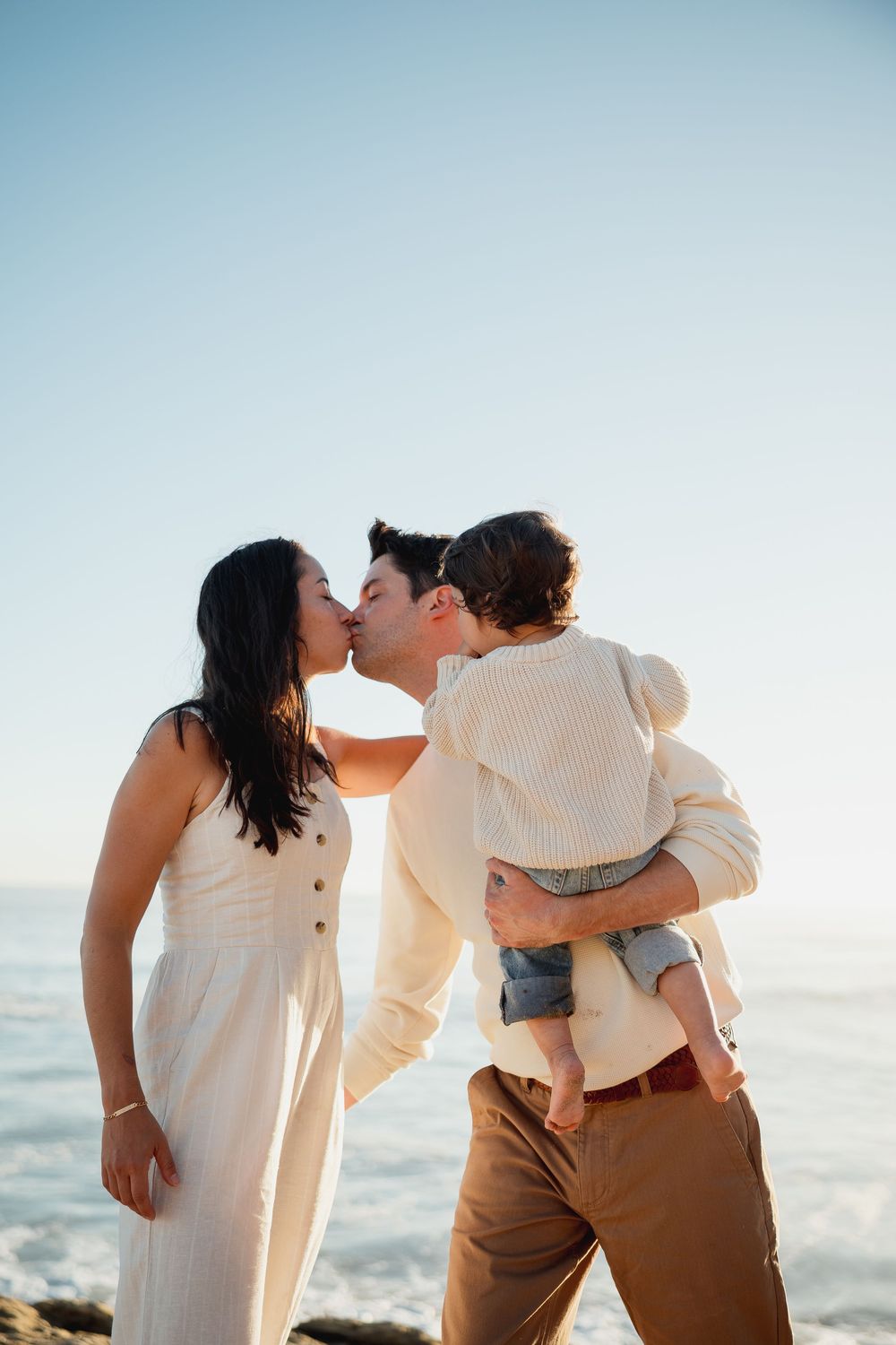 Romantic beach photoshoot sequence showing tender family moments at sunset.