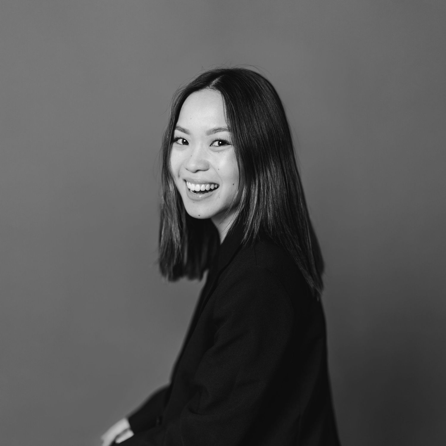 Black and white portrait series showing joyful expressions and natural poses against a simple backdrop.