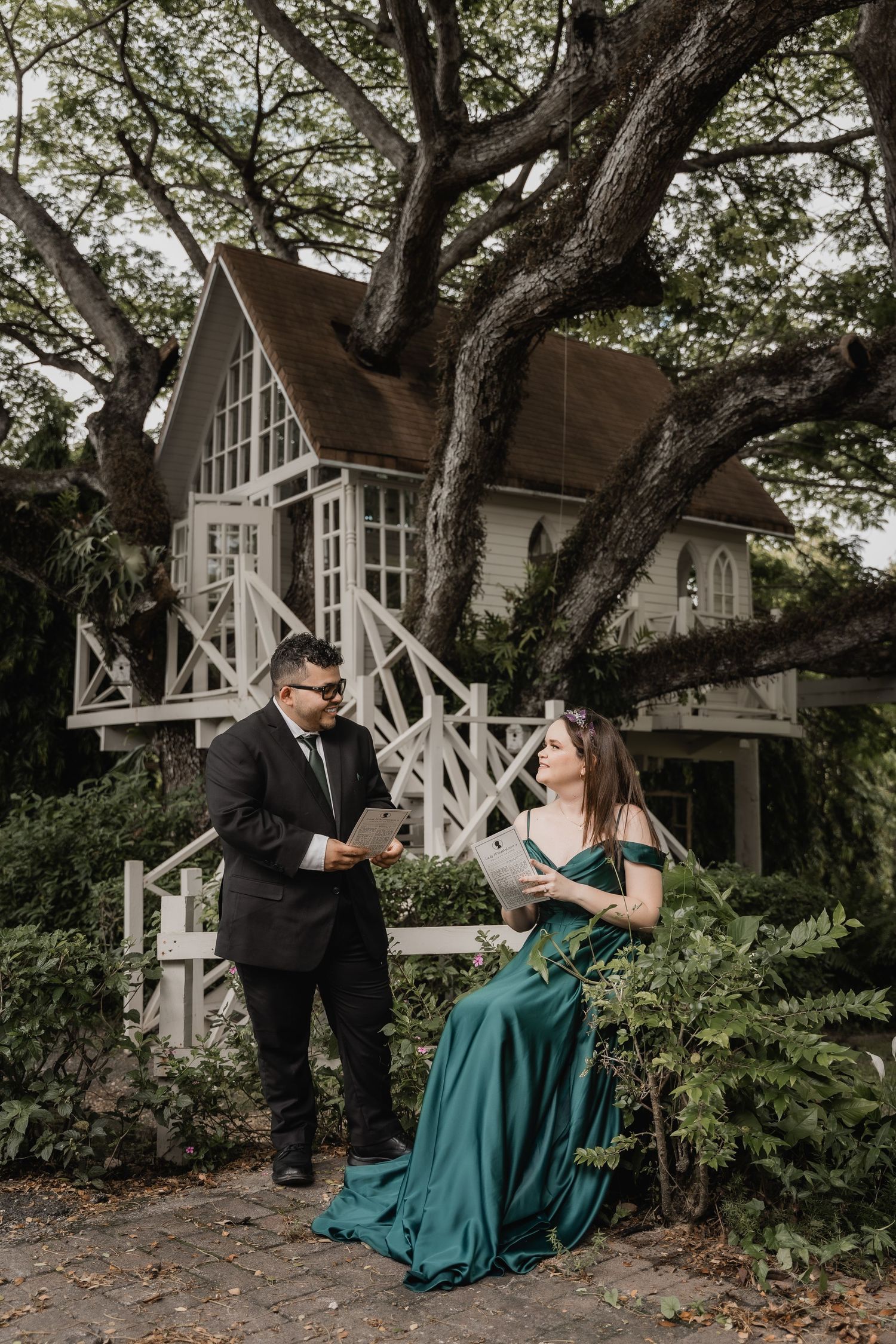 An elegant scene outside a fairytale-like treehouse cottage with vintage architecture and climbing wooden stairs.