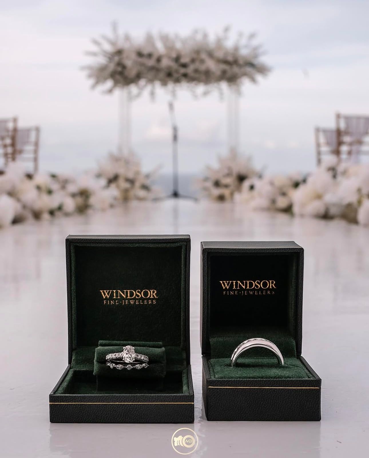 Wedding rings displayed in elegant black Windsor jewelry boxes on a white surface.