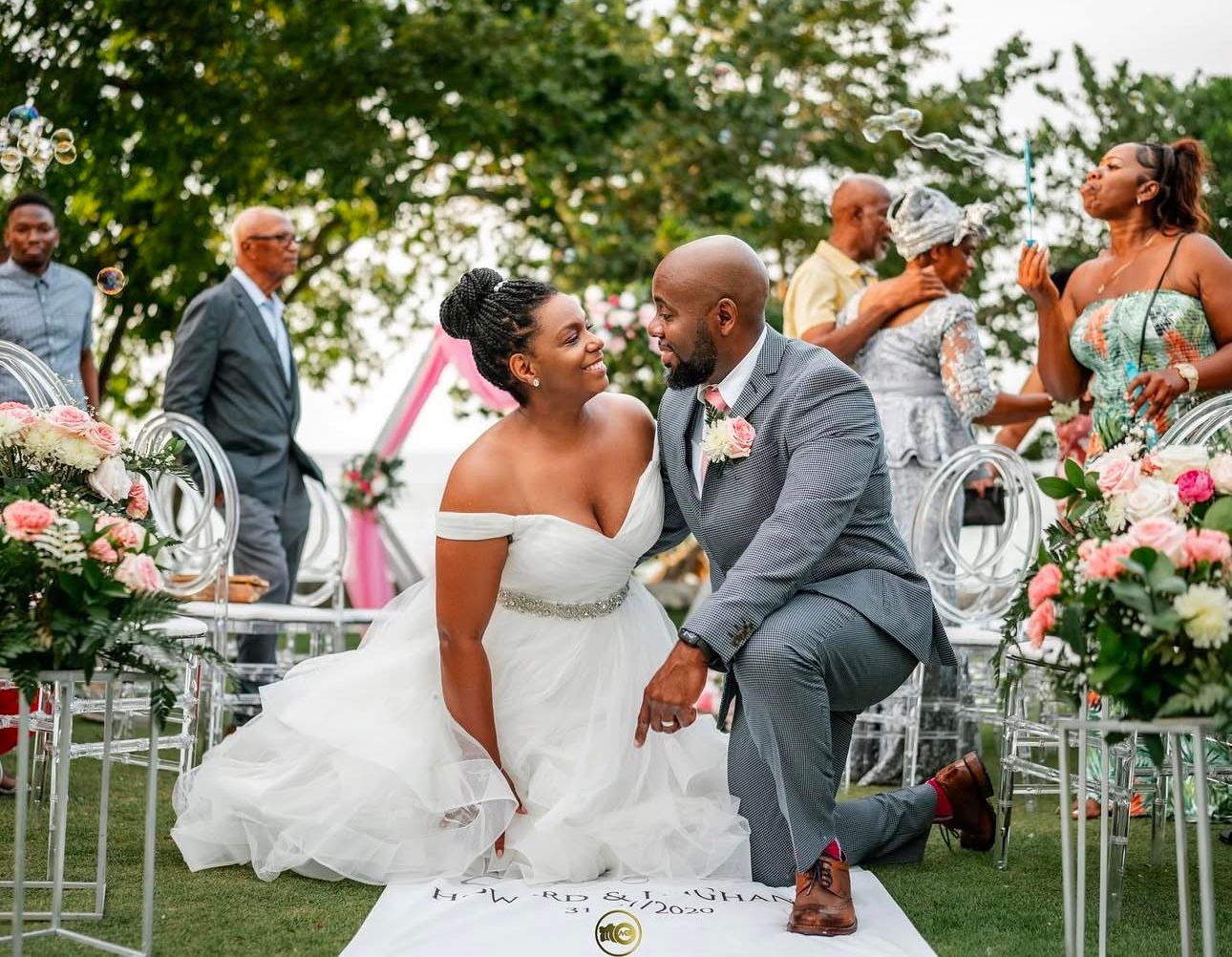 Outdoor wedding ceremony setup with floral arrangements and white chairs.