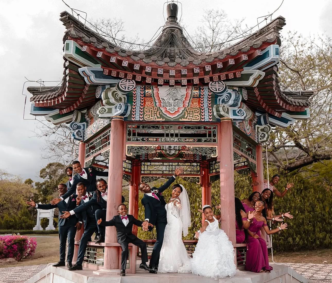 Wedding ceremony takes place under traditional Asian pagoda architecture with red accents.