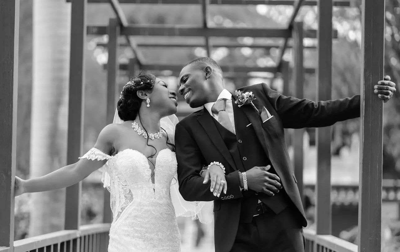 Wedding couple dances and celebrates under elegant white columns.