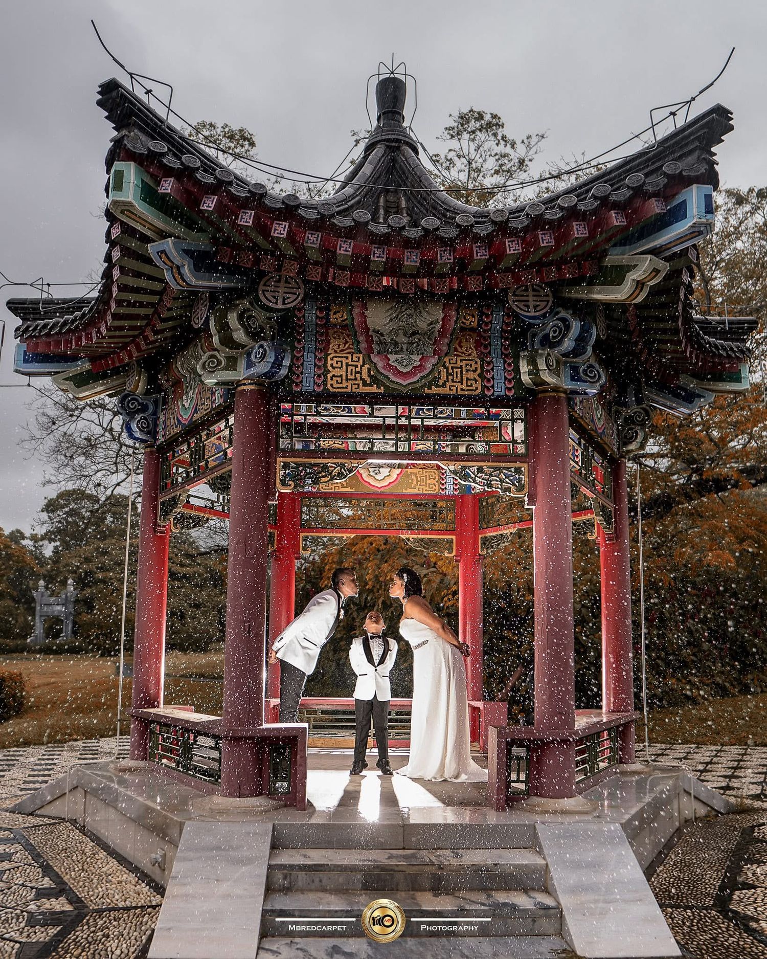 Traditional Chinese pagoda pavilion with red pillars and ornate roofing captured in a serene autumn setting.