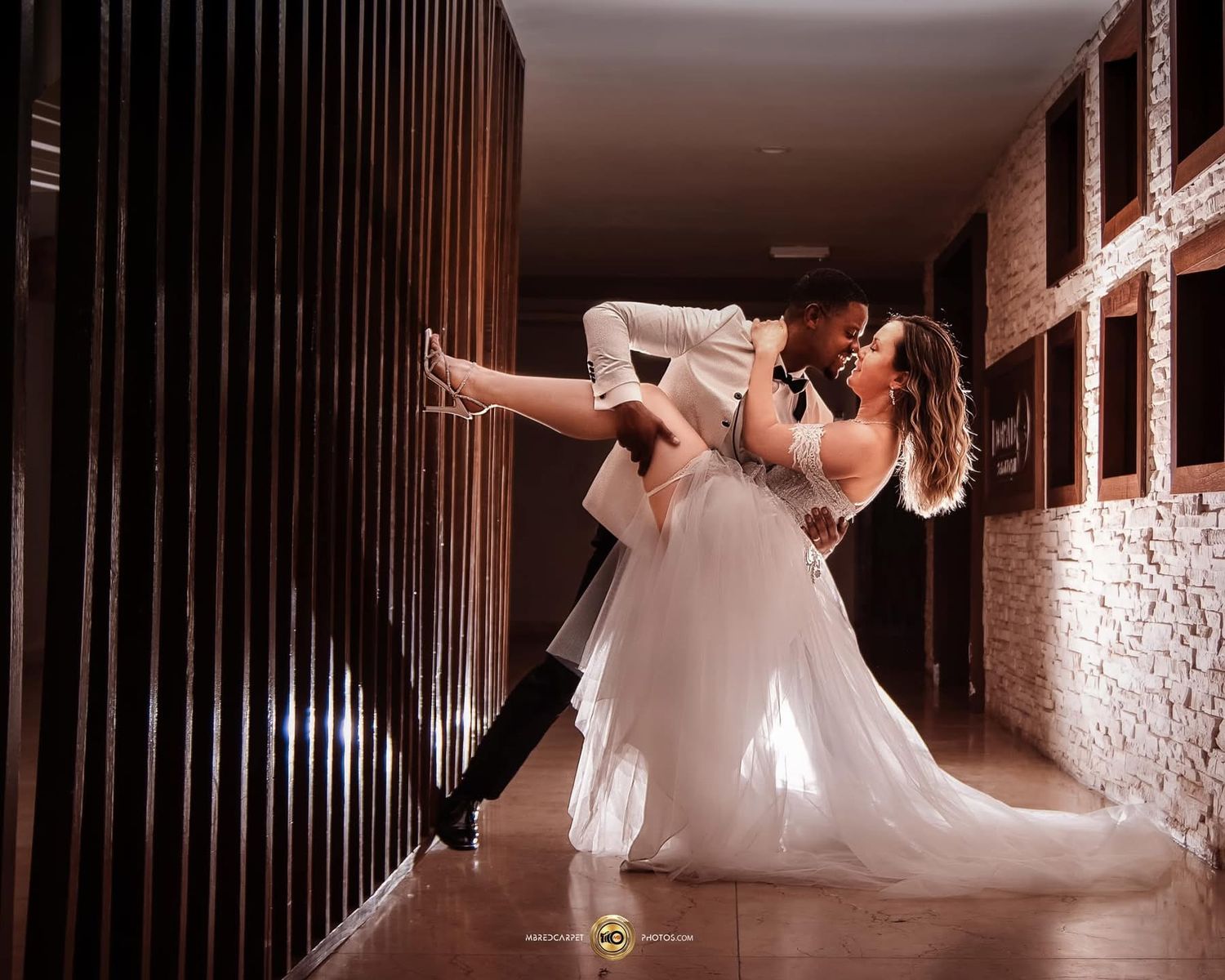 Artistic wedding photos in dark hallway with flowing white dress.