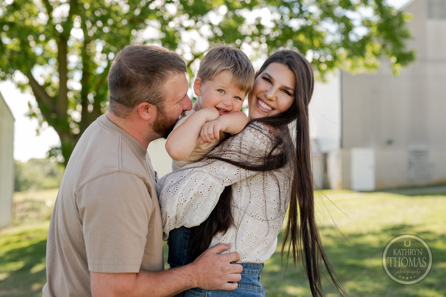 A joyful family shares a tender moment together outdoors on their farm.
