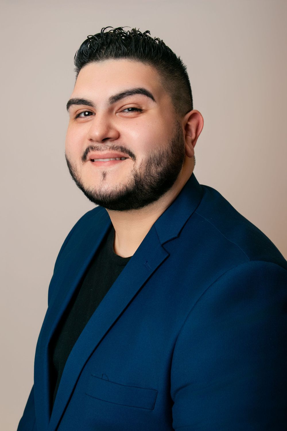 Professional studio portraits featuring navy blazer and black shirt in various expressions.