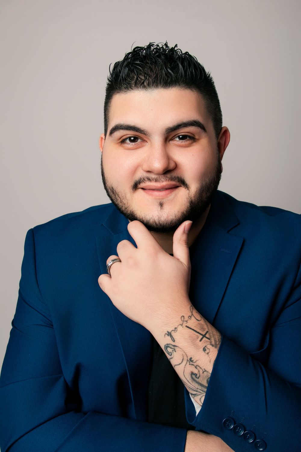 Portrait sequence showing tattoos and various poses in professional attire against gray background.