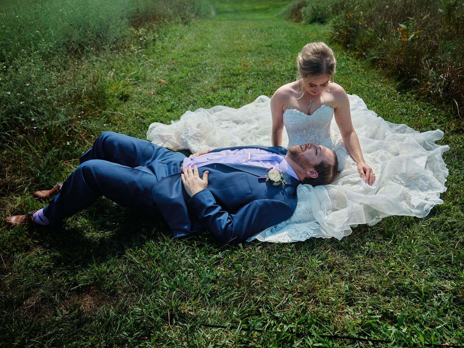 Couple sharing cake at rustic wedding reception with vintage decor.