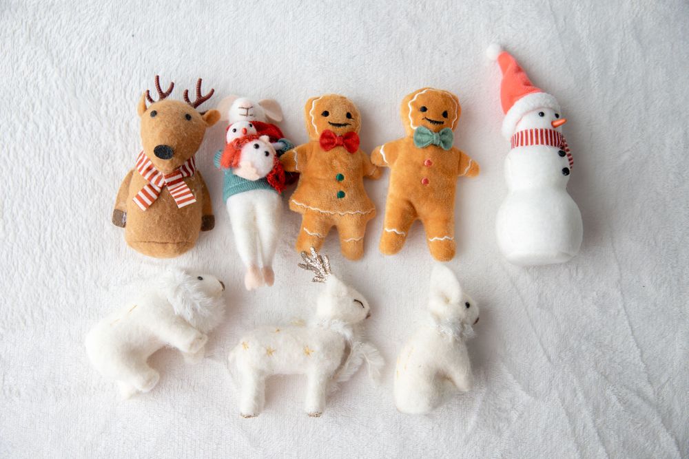 Collection of holiday stuffed toys including reindeer, gingerbread men, and snowman figures.