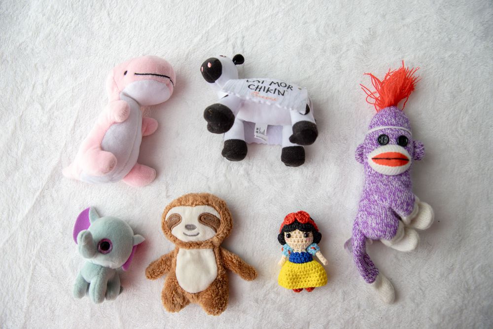 Six small plush toys including a sloth, Snow White doll, sock monkey, and animal figures.