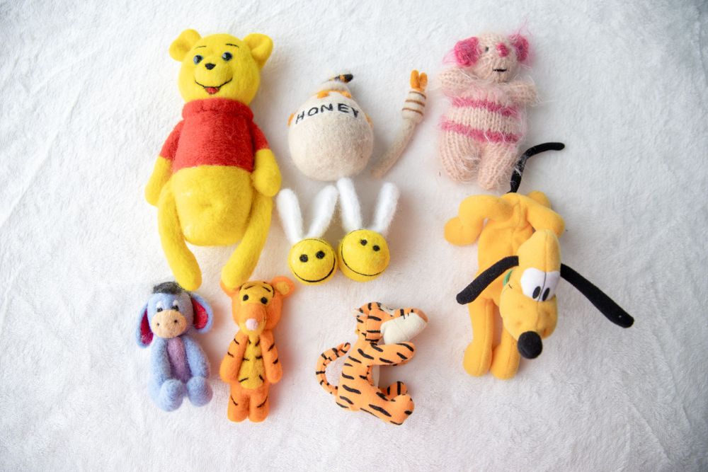 Handmade felt Winnie the Pooh character figurines including Pooh, Piglet, Eeyore, and Tigger.