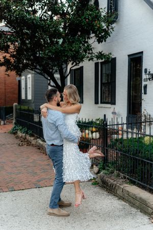 A romantic dance moment captured outside a classic white building with brick walkway.