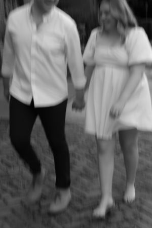 A black and white photo of a couple walking together outdoors.