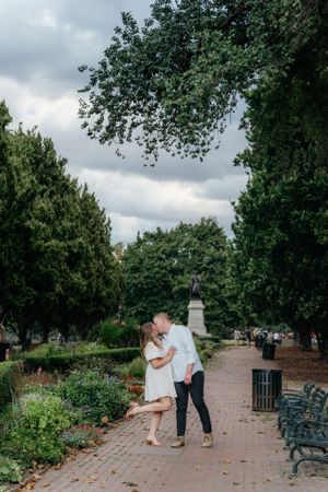 Romantic stroll along tree-lined brick pathway in a park garden.