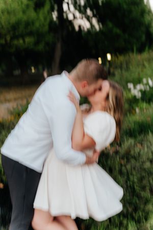 Romantic twirling pose captured in garden with motion blur effect.