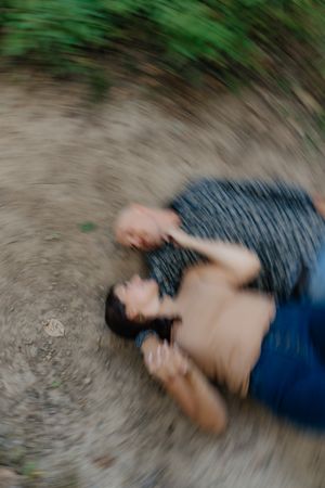 An artistic motion blur photo of two people lying on the ground.